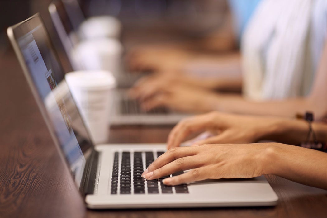 Close-up of hands typing on a laptop