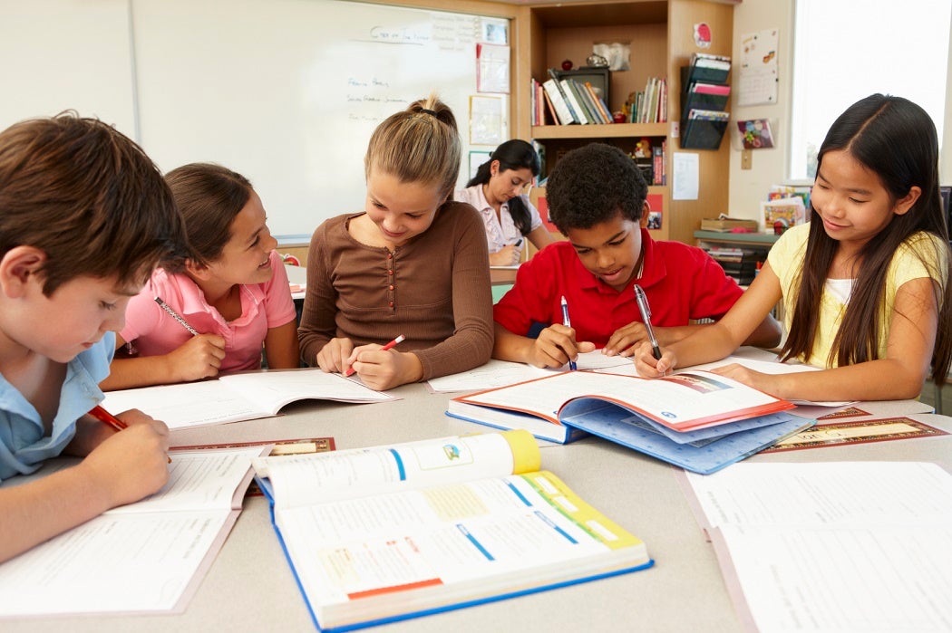 A group of elementary school aged students working on an assignment together