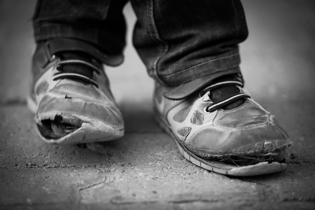 Black and white close-up of torn shoes