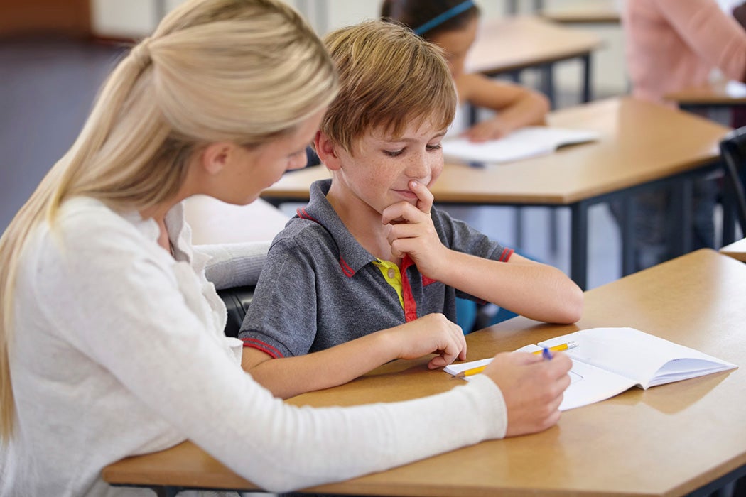 A teacher helping a student in a classroom