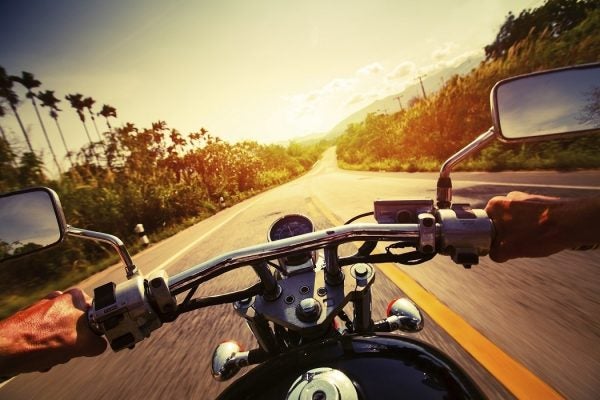 Driver riding motorcycle on an empty asphalt road