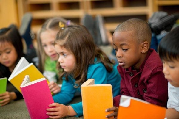 Children laying on the floor and reading together