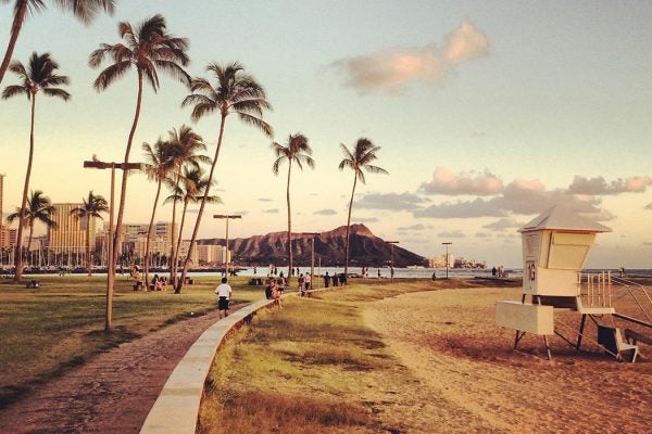 People enjoying their evening on a beach on Honolulu, Hawaii.