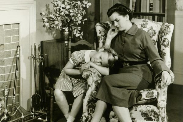 A mother and daughter sitting in the living room together.