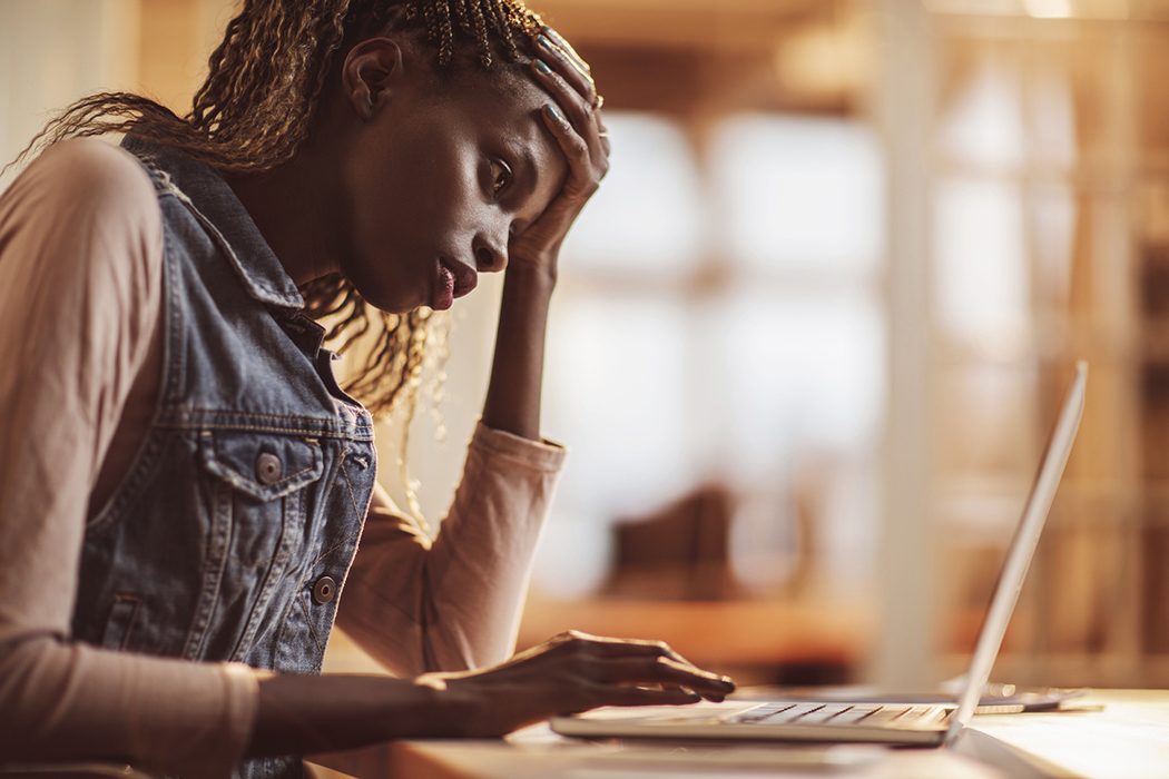 young woman distressed at a laptop