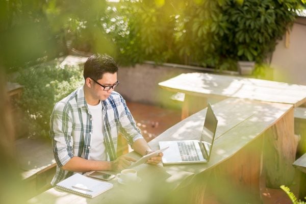 man in garden on laptop