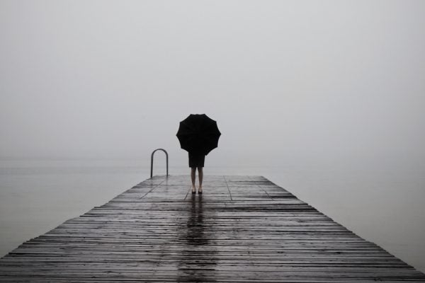 elegant woman dressed in black hiding with umbrella