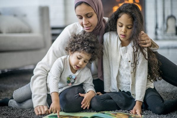 Family reading children's book