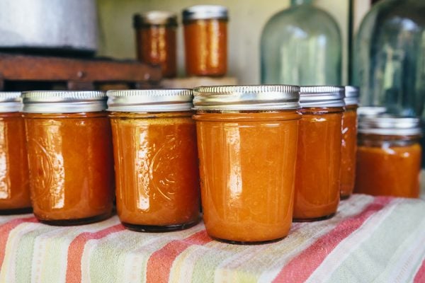 Jars of peach jam on table