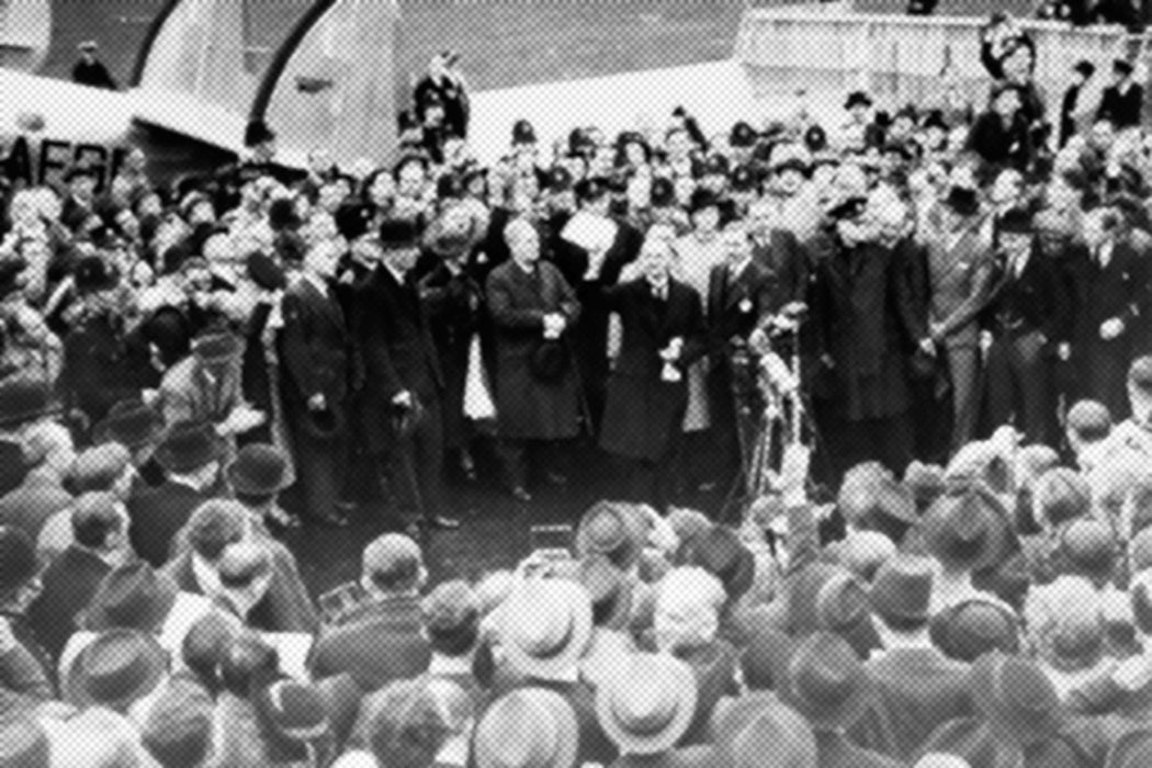 Neville Chamberlain holding the paper containing the resolution to commit to peaceful methods signed by both Hitler and himself on his return from Munich, 1938