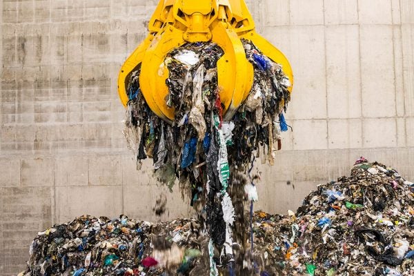 Crane lifting waste out of landfill