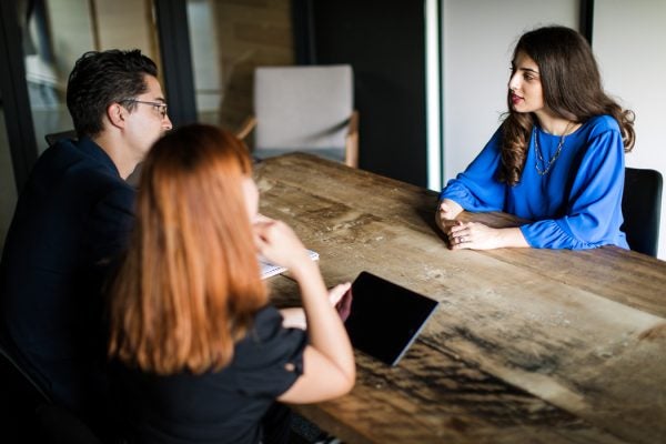 A woman at a table being interviewed for a job