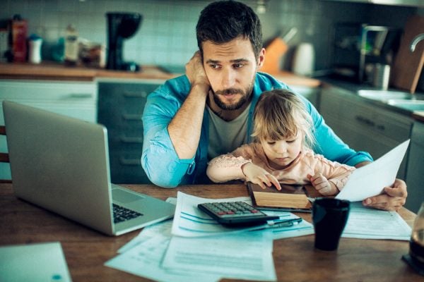 A man with his daughter paying a bill