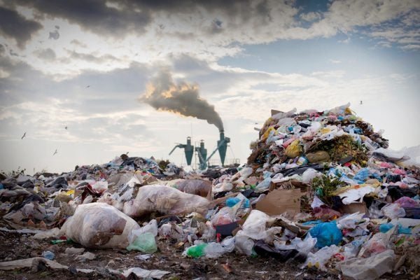 A landfill with smoke in the background