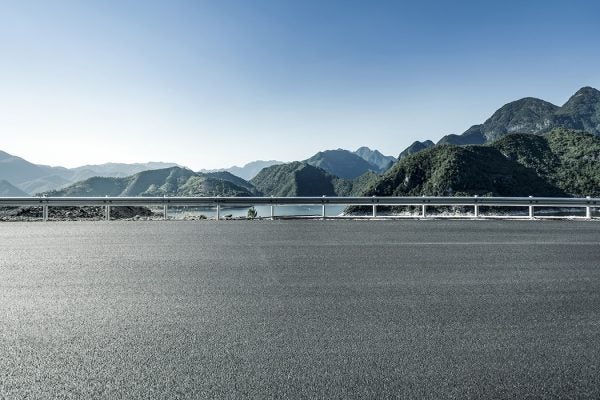 A road beside some mountains and a lake