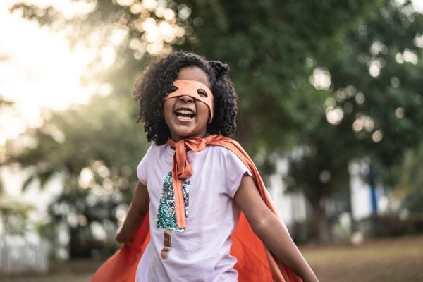 A little girl playing superhero