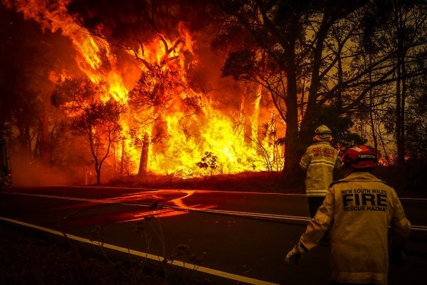 Fire and Rescue personal watch a bushfire as it burns near homes on the outskirts of the town of Bilpin on December 19, 2019 in Sydney, Australia.