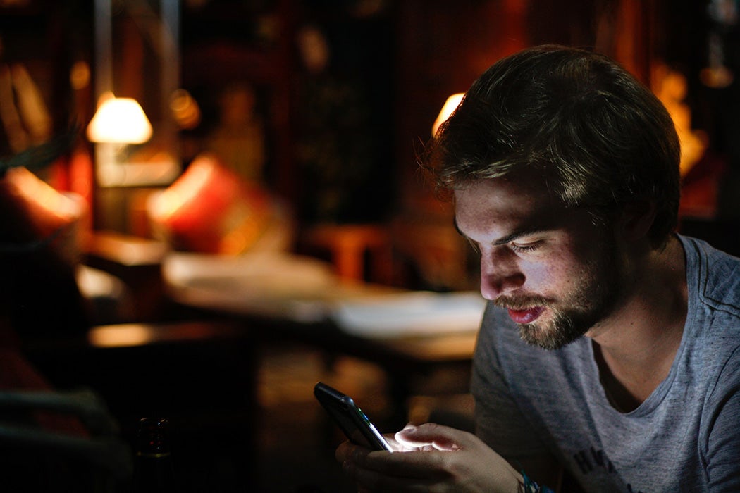 A man texting at night in his home