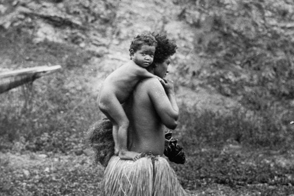 a baby uses the top of mother's skirt as a footrest and leans on her back for a comfortable ride home