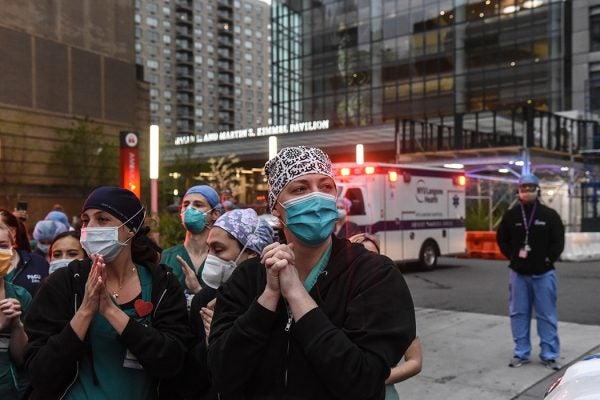 Nurses react as community members applaud them on April 30, 2020 at NYU Langone Hospital in New York City.