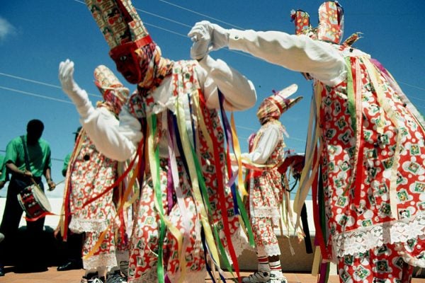 A troupe of "Masqueraders" carry whips and perform a parody of Irish dance steps, a tradition started by african slaves who were mocking their Irish slave masters.