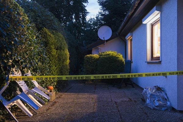 Police tape across a driveway