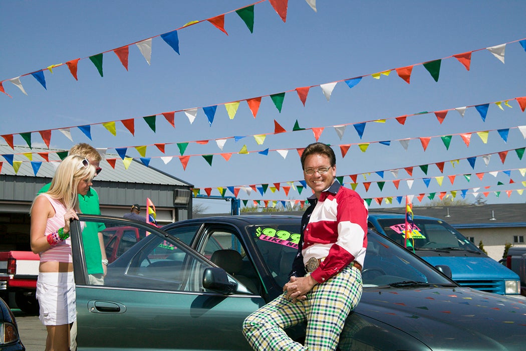 Salesman selling car to couple