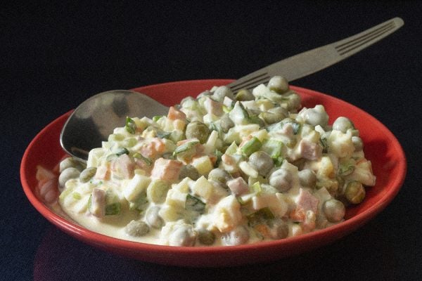 Olivier salad in a red plate on the table