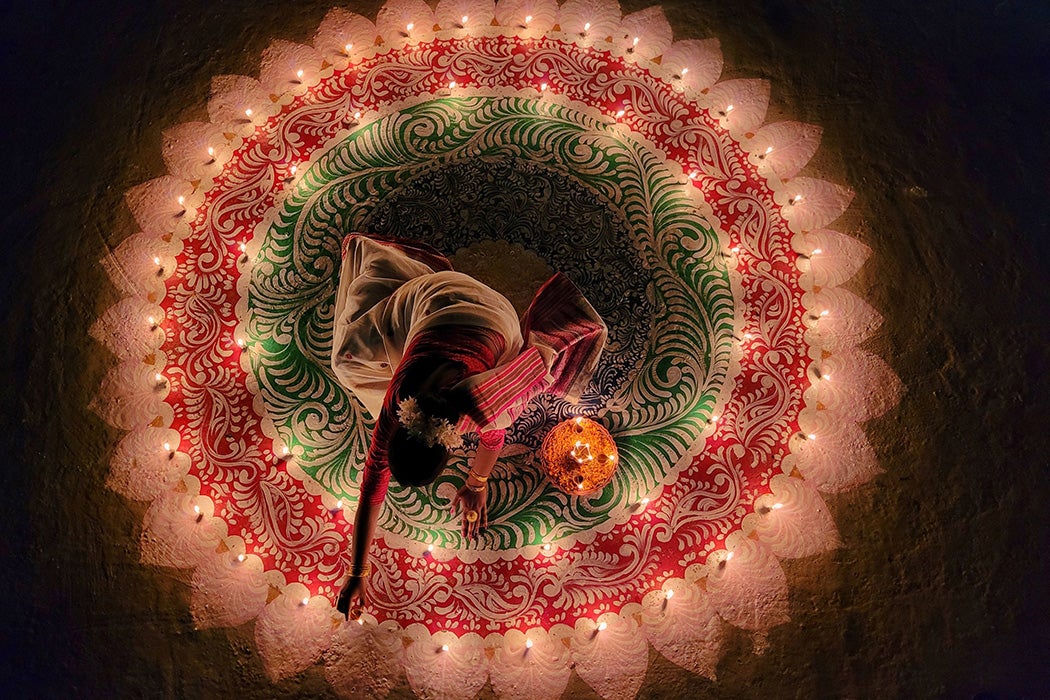 Woman lighting the candles for Diwali in India