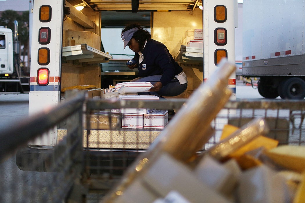 Precious Newberry, a United States Postal Service mail handler, works to unload her mail truck at the Processing and Distribution Center after collecting mail on the busiest mailing day of the year for the U.S. Postal Service on December 14, 2015 in Miami, Florida.