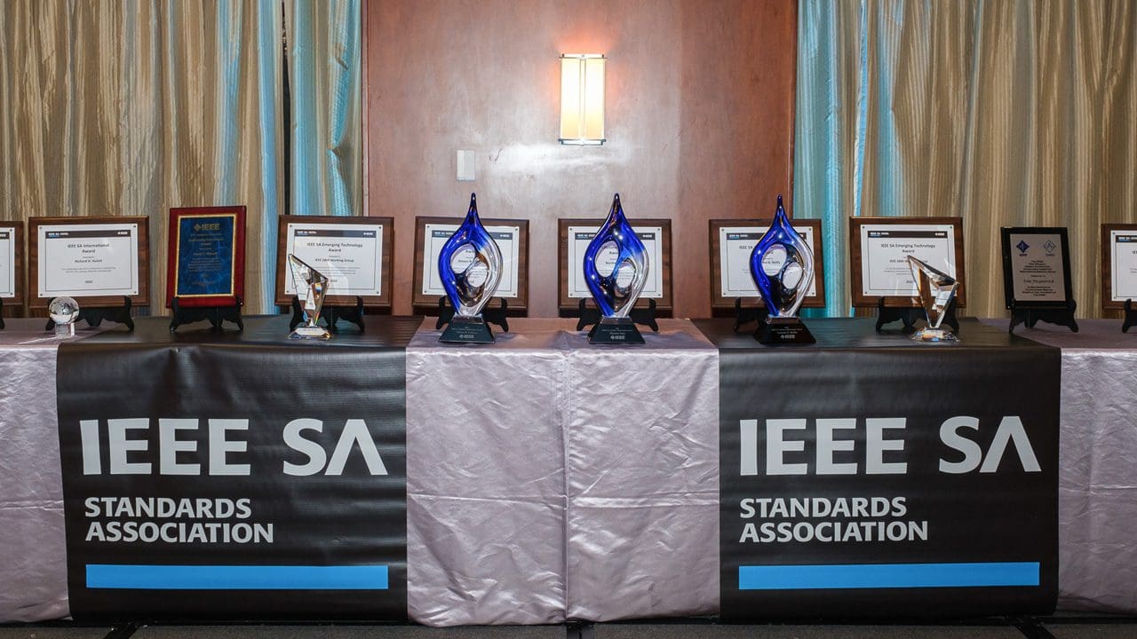 Multiple IEEE SA awards resting on a table.