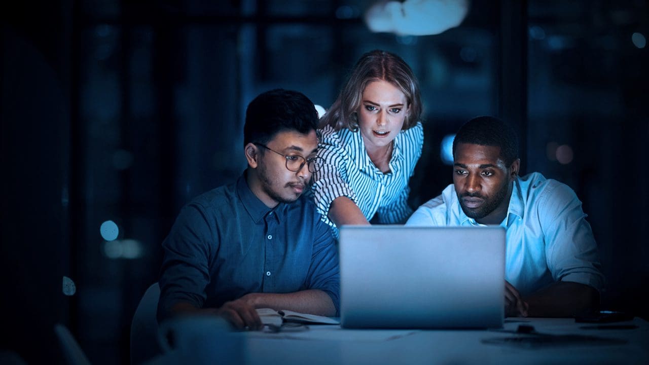 Three people looking at a computer screen