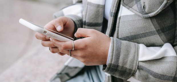 female sitting in street with cellphone