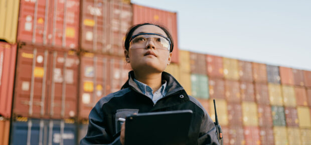 WOman taking inventory of shipping containers